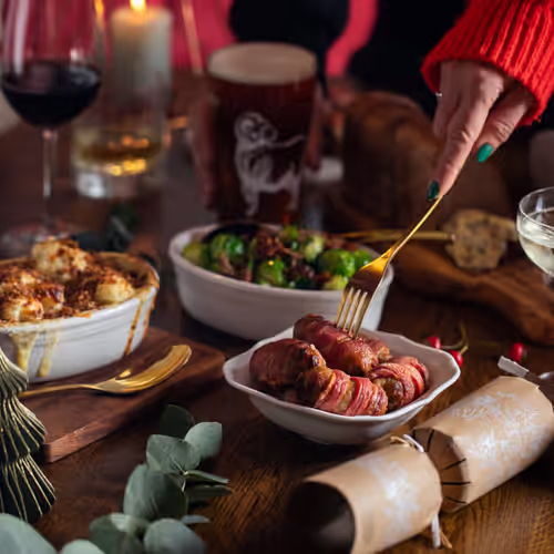 Christmas dinner table with sausages, wine, and Young's beer