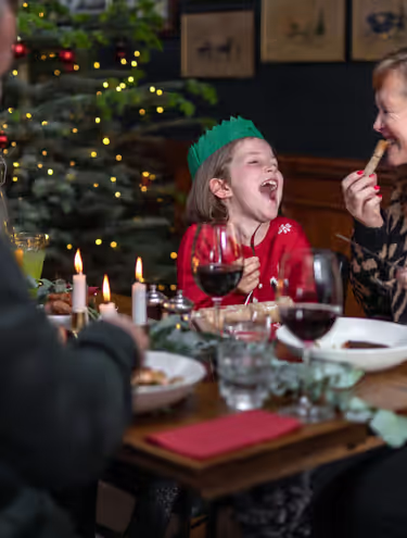 family laughing and eating Christmas dinner at a Young's pub