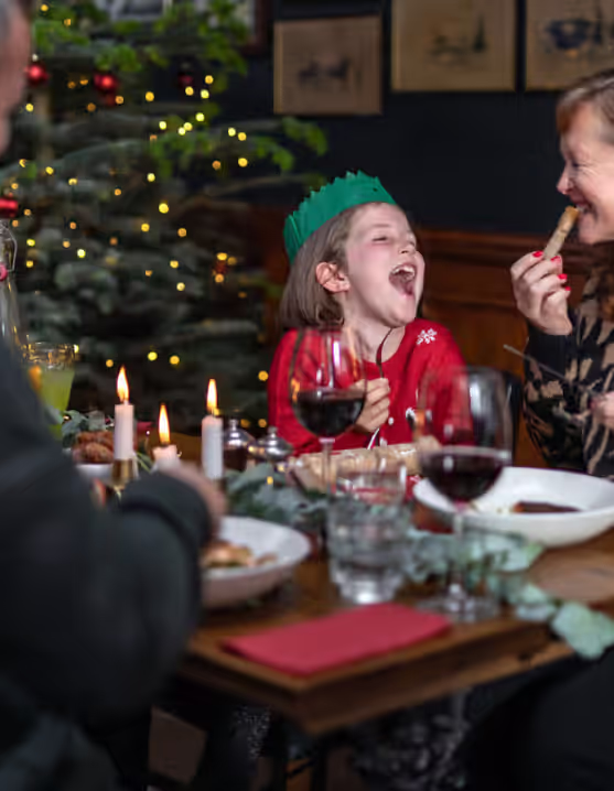 family laughing and eating Christmas dinner at a Young's pub