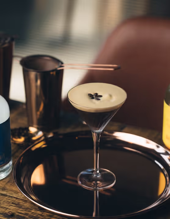 Espresso Martini on a tray next to a bottle of Lyre's non-alcoholic spritz
