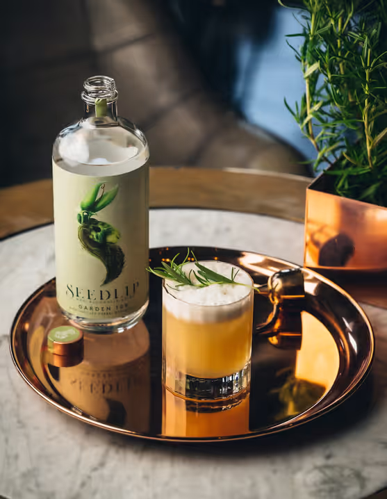 glass and bottle of Seedlip Garden Sour on a tray