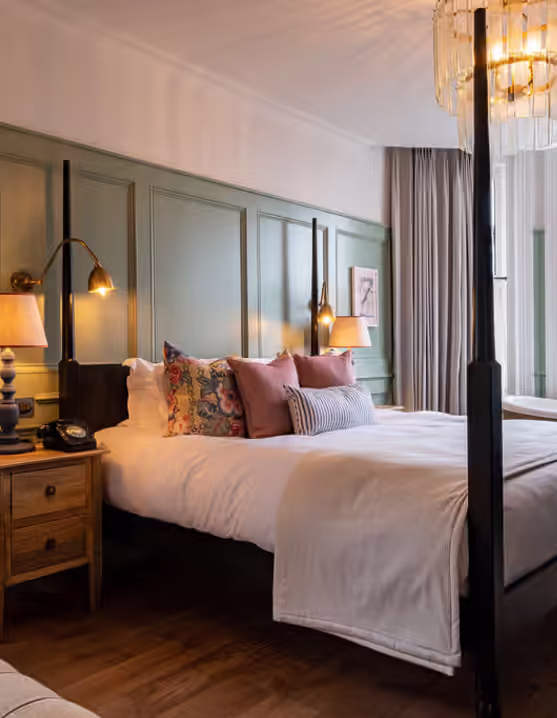 hotel room with a four poster bed and green accents