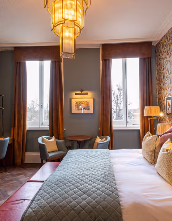 spacious hotel room with a king-size bed and a writing desk