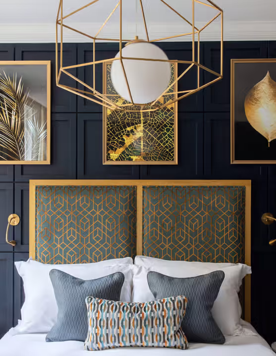 hotel room with gold and blue accents, patterned headboard, and modern art