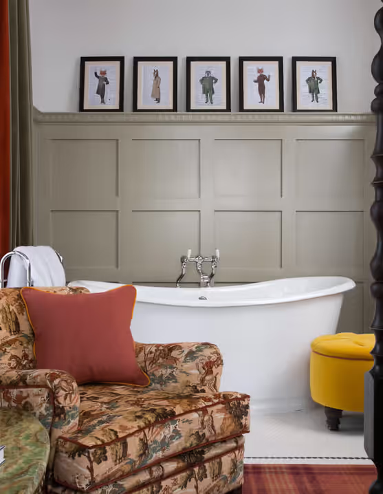 luxurious hotel room with freestanding bathtub and armchair