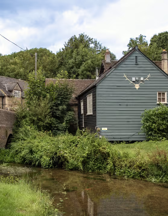 stone bridge over a river with a traditional pub on the bank