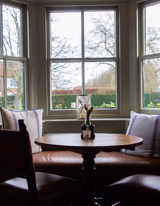 table and chairs in front of a big window
