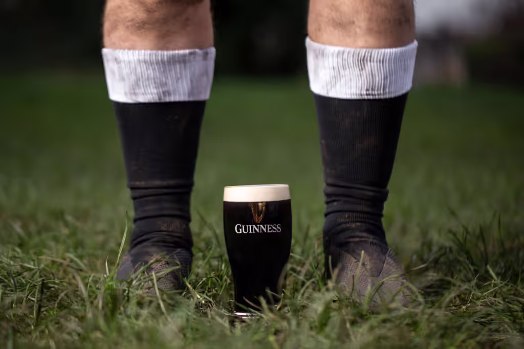 pint of Guinness in the grass between a rugby player's feet