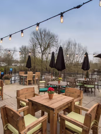 outdoor dining area with river view and fairy lights