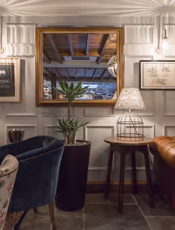cozy pub lounge with leather sofas, colourful armchairs and framed photos