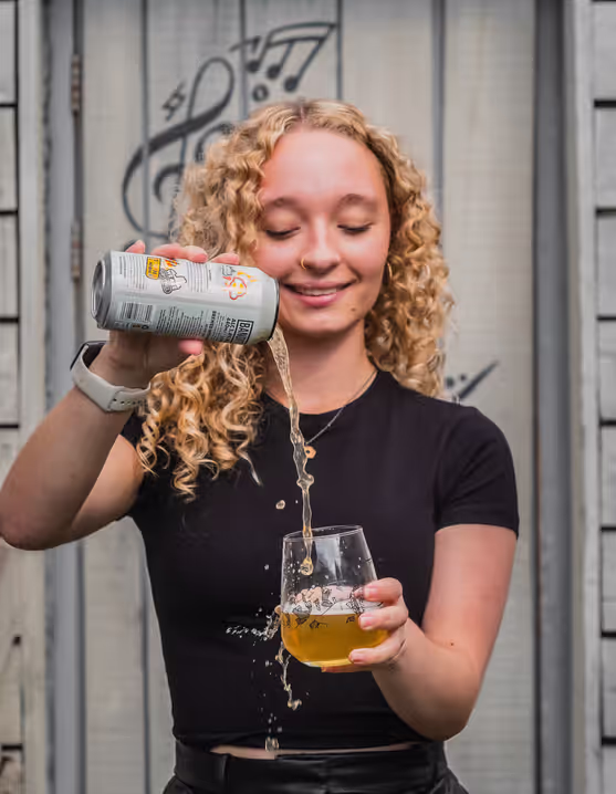 girl pouring a canned beer into a glass