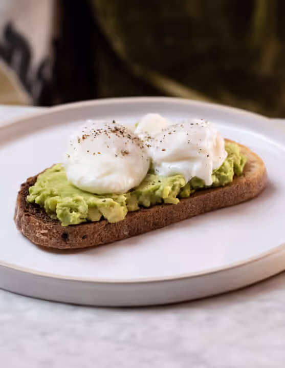 plate of poached eggs and smashed avocado on toast