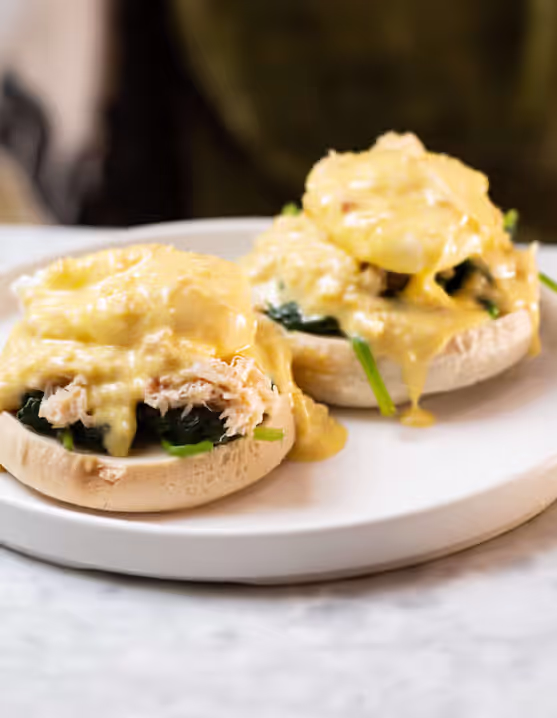 plate of eggs benedict with sautéed baby spinach and a Devon crab packed hollandaise sauce