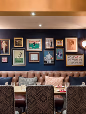 pub dining area with framed artwork and leather banquettes