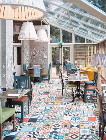 bright and airy restaurant with patterned floor and colorful chairs