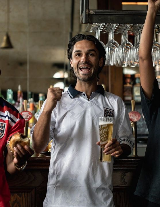 friends in a Young's pub drinking pints and cheering