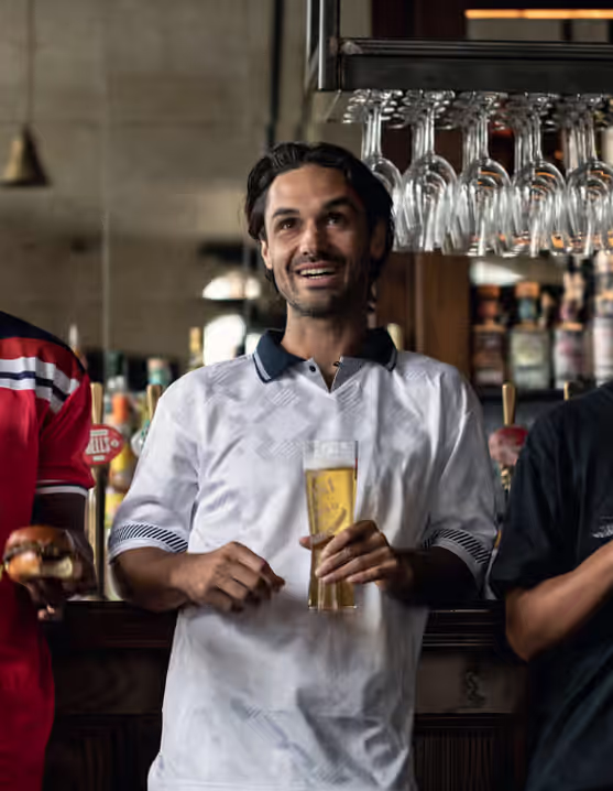 three friends watching the game with beers at a Young's pub