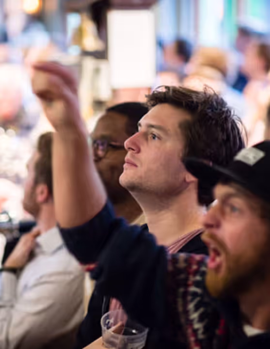 people cheering and watching a game at a Young's pub