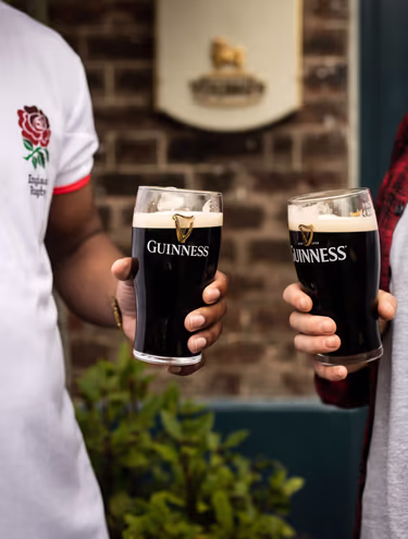 two people holding pints of Guinness