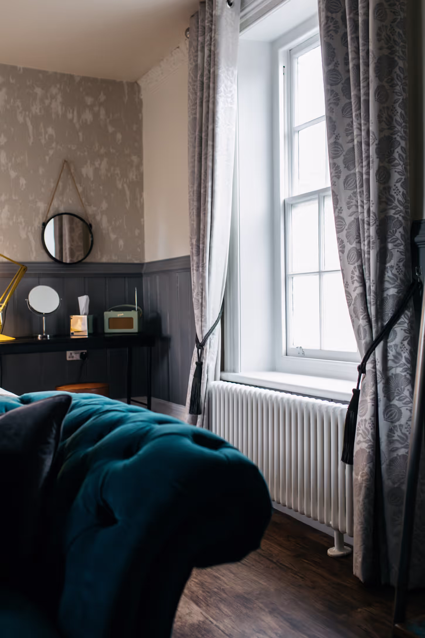 hotel room with plush velvet sofa and large window